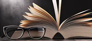 Composition With Open Book Drucke: Composition with open book and glasses on the table