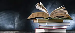 Open Book Drucke: A composition with an open book lying on a stack of other books
