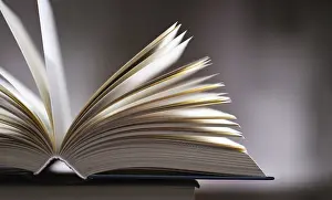 Open Book Drucke: A composition with an open book lying on a stack of other books