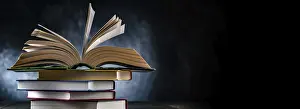 Open Book Drucke: A composition with an open book lying on a stack of other books
