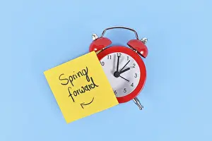 Daylight Saving Time Concept Drucke: Concept for summer daylight saving time with clock and note saying Spring forward