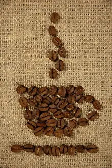 Symbolic Picture Of Breakfast Drucke: Conceptual artistic pattern of a cup of coffee made from coffee beans on a sacking background