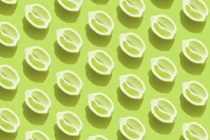 Green Background Design Drucke: Conceptual pattern with halves of lemon with shadow on green background