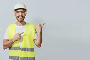 Construction Worker Portrait Drucke: Construction engineer with vest pointing at an advertisement