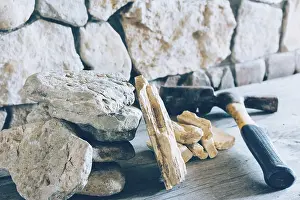 Fortress Architecture Drucke: Construction Hammer And Stack Flagstone Against The Wall Of Stone Closeup