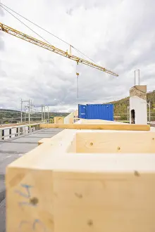 Cloudy Sky Architecture Drucke: Construction site with wooden structures and a blue container under cloudy sky