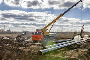 Construction Crane Drucke: Construction work on the pipe laying of the pipeline into the trench using a crane
