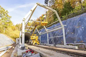 Black Forest Infrastructure Drucke: Construction work on a tunnel opening with cranes and workers against an autumn backdrop