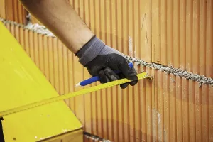 Construction Worker Drucke: Construction worker erecting a brick wall in a building shell