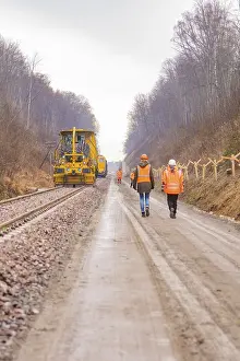 Deserted Construction Site Europe Drucke: Construction worker on a rail line in the forest