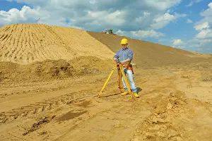 Young Engineer Drucke: Construction worker with theodolite