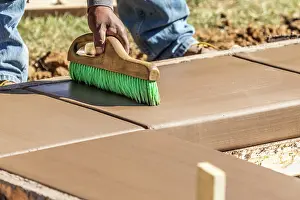 Cement Finishing Techniques Drucke: Construction Worker Using Brush On Wet Cement Forming Coping Around New Pool