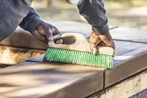 Real Estate Construction Industry Drucke: Construction worker using brush on wet cement forming coping around new pool