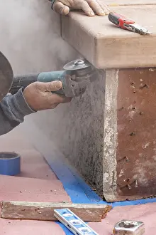 Manpower In Construction Drucke: Construction worker using grinder at construction site