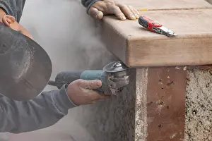 Male Construction Worker Drucke: Construction worker using grinder at construction site