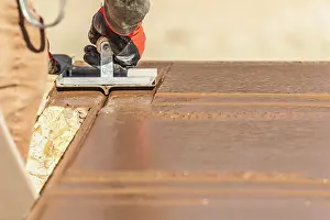 Swimming Pool Building Drucke: Construction Worker Using Hand Groover On Wet Cement Forming Coping Around New Pool
