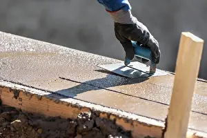 Construction Site Photos Drucke: Construction Worker Using Hand Groover On Wet Cement Forming Coping Around New Pool