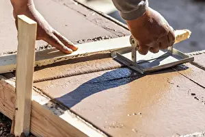 Swimming Pool Building Drucke: Construction Worker Using Hand Groover On Wet Cement Forming Coping Around New Pool