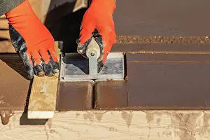 Construction Worker Safety Drucke: Construction Worker Using Hand Groover On Wet Cement Forming Coping Around New Pool