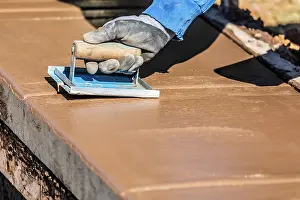 Construction Site Laborer Drucke: Construction Worker Using Hand Groover On Wet Cement Forming Coping Around New Pool