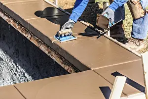 Wet Cement Coping Drucke: Construction worker using hand groover on wet cement forming coping around new pool
