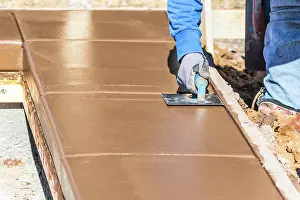 Swimming Pool Builder Drucke: Construction Worker Using Hand Groover On Wet Cement Forming Coping Around New Pool
