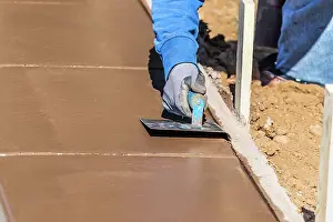 Cement Finishing Techniques Drucke: Construction Worker Using Hand Groover On Wet Cement Forming Coping Around New Pool