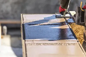 Construction Industry Workforce Drucke: Construction worker using hand groover on wet cement forming coping around new pool