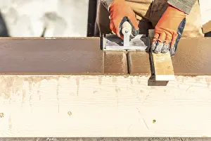 Construction Industry Workforce Drucke: Construction worker using hand groover on wet cement forming coping around new pool
