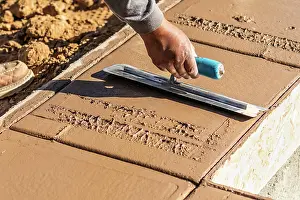 Cement Forming Techniques Drucke: Construction Worker Using Trowel On Wet Cement Forming Coping Around New Pool