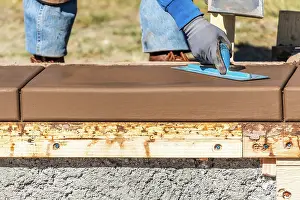 Wet Cement Installation Drucke: Construction Worker Using Trowel On Wet Cement Forming Coping Around New Pool