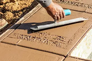Pool Installation Process Drucke: Construction Worker Using Trowel On Wet Cement Forming Coping Around New Pool