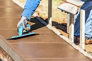 Building A New Pool Drucke: Construction Worker Using Trowel On Wet Cement Forming Coping Around New Pool