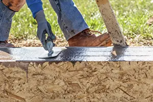 Construction Site Photos Drucke: Construction Worker Using Trowel On Wet Cement Forming Coping Around New Pool