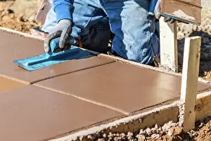 Swimming Pool Coping Installation Drucke: Construction Worker Using Trowel On Wet Cement Forming Coping Around New Pool