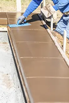 Construction Site Laborer Drucke: Construction worker using trowel on wet cement forming coping around new pool
