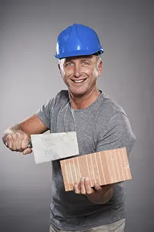 Drucke von Bauarbeiter mit Helm, hält einen Trowel und eine Ziegelstein, Mannheim, Baden-Württemberg, Deutschland Bauarbeiter mit Helm, hält einen Trowel und eine Ziegelstein, Mannheim, Baden-Württemberg Mannheim Drucke: Bauarbeiter mit Schutzhelm