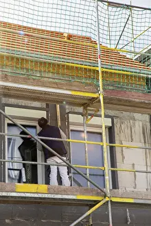 Energy Saving Construction Drucke: Construction workers insulate a house facade