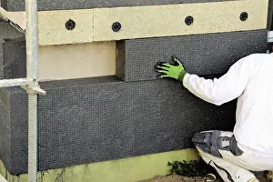 Energy Efficient Homes Drucke: Construction workers insulate a house facade