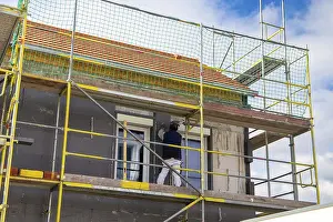 Energy Saving Construction Drucke: Construction workers insulate a house facade