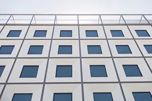 Symmetrical Architectural Style Drucke: A contemporary building facade with a geometric pattern of windows creates a striking visual effect