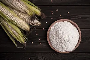 Close Up Corn Drucke: Corn cobs, corn flour, on a wooden table