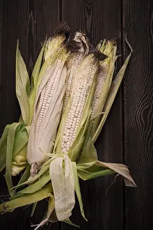 Rustic Food Style Drucke: Corn cobs, on a wooden table, top view