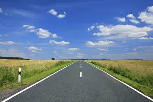 Cloudy Blue Sky Photography Drucke: Country road through fields in summer