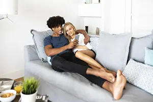 Peaceful Atmosphere Drucke: A couple cuddles on a comfortable sofa