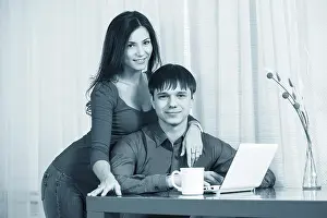 Married Couple Using Laptop Drucke: Couple having coffee while using a laptop in their kitchen
