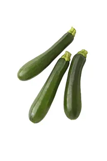 Bright White Background Photos Drucke: Three courgettes, studio shot against a white background