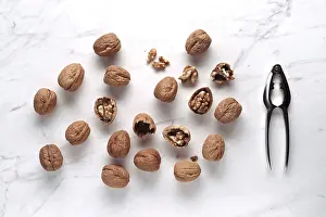 Country Style Kitchen Decor Drucke: Whole and cracked walnuts scattered on a marble surface