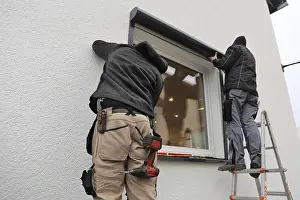 Professional Window Installation Drucke: Craftsmen install a front-mounted roller shutter