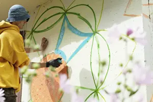 Straßenkünstler Drucke: Kreative Kunst, Bild eines jungen Mannes beim Malen von Graffiti.